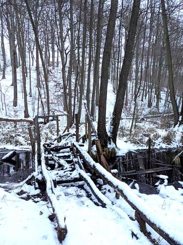 Zerfallene Brücke am Ufer des winterlichen Neumühler Sees